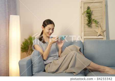 女性智能手機客廳在晚上 84233342