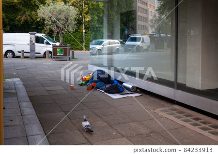 sleeping homeless man on the city street 84233913