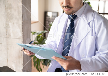 Doctor's hand to fill out questionnaires and medical records Doctor's hand to fill out questionnaires and medical records 84234188