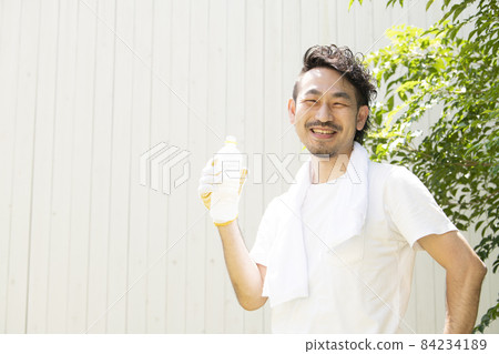 A man with a refreshing smile looking at the camera with a beard who rehydrates at the outdoor work in the heat of the heat so as not to suffer from heat stroke A man with a refreshing smile looking at the camera with a beard who rehydrates at the outdoor work in the heat of the heat so as not to suffer from heat stroke 84234189