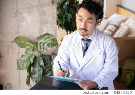 Japanese doctor who fills out a medical record while looking at the patient's eyes and counseling the story 1 Japanese doctor who fills out a medical record while looking at the patient's eyes and counseling the story 1 84234190