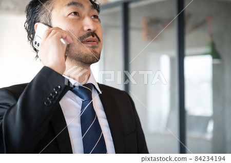 There is an up-copy space for Japanese men in managerial style who answer the phone on the go There is an up-copy space for Japanese men in managerial style who answer the phone on the go 84234194
