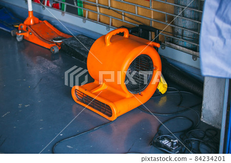 Orange blower fan machine on floor. Heavy Duty Industrial Portable Blower Fan on floor Orange blower fan machine on floor. Heavy Duty Industrial Portable Blower Fan on floor 84234201