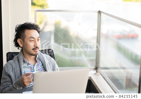 一邊工作一邊在陽台上放鬆的日本男人 84235145