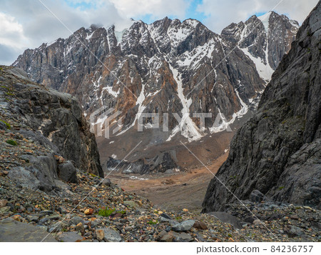 Narrow passage through the mountain couloir.Dangerous mountain couloir. Colorful sunny landscape with cliff and big rocky mountains and epic deep gorge. Narrow passage through the mountain couloir.Dangerous mountain couloir. Colorful sunny landscape with cliff and big rocky mountains and epic deep gorge. 84236757