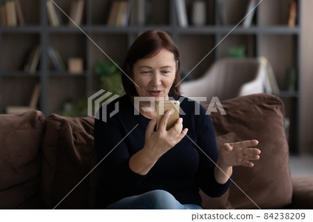 Mature woman using smartphone, chatting online by video call 84238209