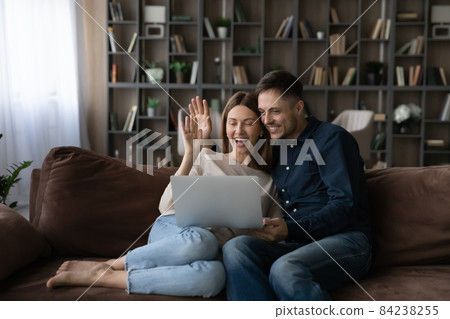 Happy couple hugging waving hands, chatting online by video call 84238255
