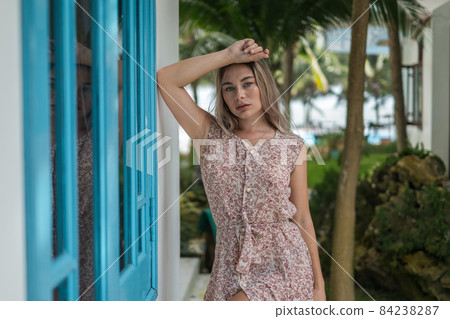 Portrait of attractive caucasian woman with blond long hair wearing casual dress, looks directly at camera. Face expressions concept. 84238287