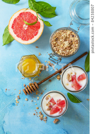 Vegan healthy breakfast. Granola with greek yogurt, honey and grapefruit in a glass. Top view flat lay background. 84238807