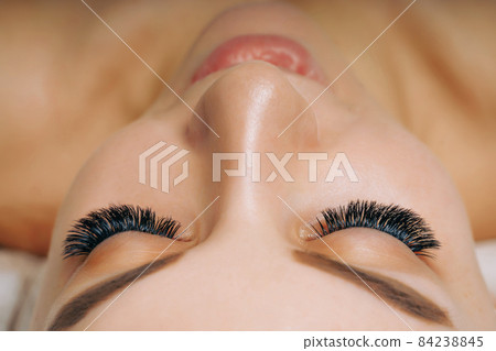 Eyelash Extension Procedure. Woman Eye with Long Eyelashes. Close up, selective focus. 84238845