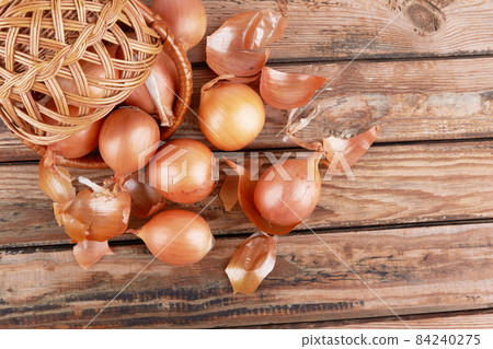 Onions on wooden background 84240275