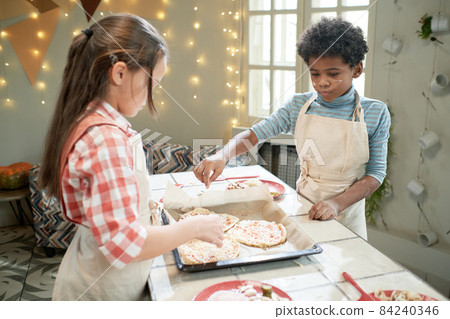 Children making pizza together at the table, they adding ingredients on the dough 84240346