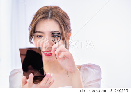 Young female eyelash curler to make up Young female eyelash curler to make up 84240355