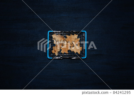 Modern flat lay with cookies Christmas tree shape in shopping cart on dark blue background. Hard flash light. Trendy christmas food background, greeting card Modern flat lay with cookies Christmas tree shape in shopping cart on dark blue background. Hard flash light. Trendy christmas food background, greeting card 84241295