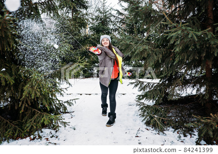 Outdoor activities for happy winter holidays. Winter Bucket List, Fun Activities and Things for adults When its Cold outside. Happy girl playing with snow and enjoying life in winter park, forest 84241399