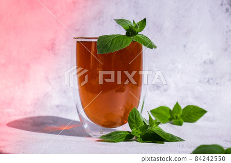 Tea with mint. Transparent cup of herbal tea with fresh mint. Healthy melissa tea natural organic aromatic drink in glass cup 84242550