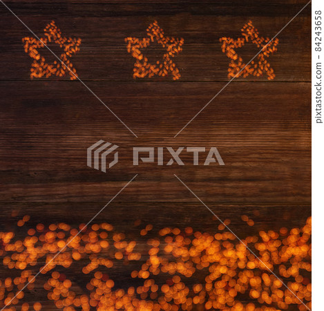 Three stars of lights on a wooden brown background with copy space, new year's card 84243658