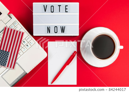 Online voting and elections concept. Laptop and coffee cup on a red background. Place for text. Online voting and elections concept. Laptop and coffee cup on a red background. Place for text. 84244017