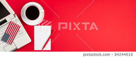 Online voting and elections concept. Laptop and coffee cup on a red background. Banner format 84244018