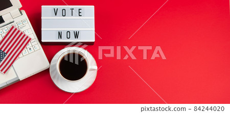 Online voting and elections concept. Laptop and coffee cup on a red background. Banner format Online voting and elections concept. Laptop and coffee cup on a red background. Banner format 84244020