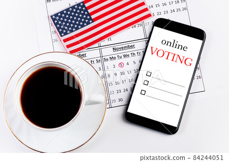 Online voting for elections November 3, 2020. Cup of coffee and calendar on the background of the USA flag. Online voting for elections November 3, 2020. Cup of coffee and calendar on the background of the USA flag. 84244051
