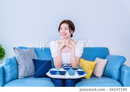 Young woman relaxing in a room Young woman relaxing in a room 84247199