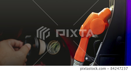 Fuel nozzle on a black background and a open the fuel cap double exposure backdrop 84247237