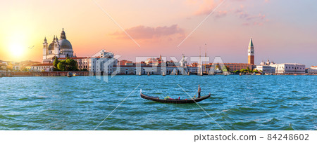Panoramic view of Venice lagoon and gondola at sunset, Italy 84248602
