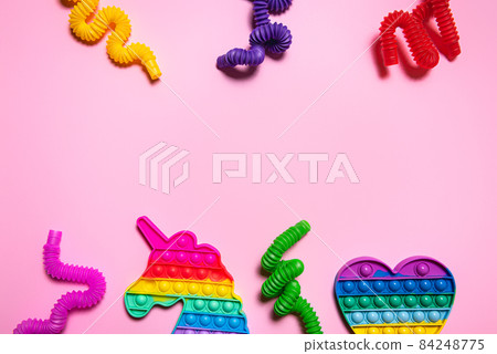Colorful antistress toys on pink paper background with copy space Colorful antistress toys on pink paper background with copy space 84248775