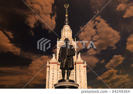 View of the monument to Mikhail Vasilyevich Lomonosov (sculptor N. V. Tomsky and architect L. V. Rudnev, 1953)from building of Moscow State University (MSU), on the background of the sky, Russia 84249364