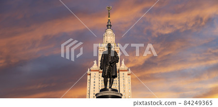 View of the monument to Mikhail Vasilyevich Lomonosov (sculptor N. V. Tomsky and architect L. V. Rudnev, 1953)from building of Moscow State University (MSU), on the background of the sky, Russia 84249365