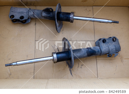 The old shock absorber in the crate box that was removed from a small sedan after being inspected. The old shock absorber in the crate box that was removed from a small sedan after being inspected. 84249589
