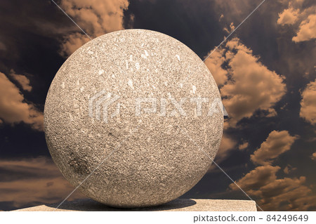Large granite ball on the background of the sky with clouds Large granite ball on the background of the sky with clouds 84249649