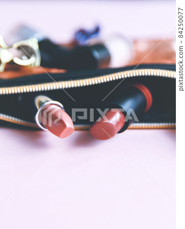 Bright composition of fashion accessories. Glitter sequins cosmetic bag with nail polishes, lipsticks, hair pins. Objects on soft pastel background. Flat lay, top view. Bright composition of fashion accessories. Glitter sequins cosmetic bag with nail polishes, lipsticks, hair pins. Objects on soft pastel background. Flat lay, top view. 84250077