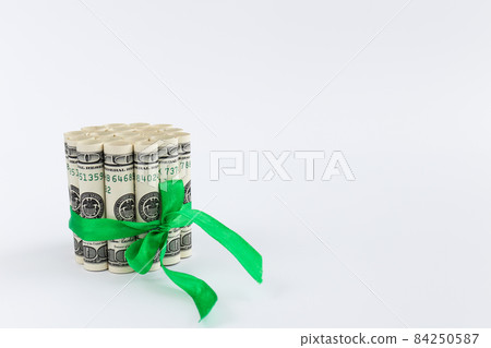100 dollar bills in rolls tied with green ribbon. Money gift. 100 dollar bills in rolls tied with green ribbon. Money gift. 84250587