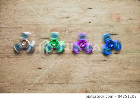 Colored fidget spinners stress relieving toy on wooden background 84251102
