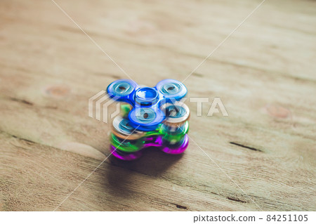 Colored fidget spinners stress relieving toy on wooden background 84251105