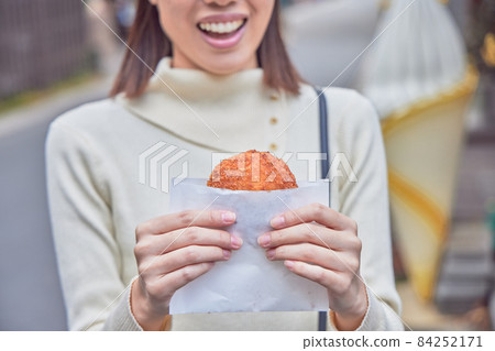 A young woman eating and walking in Yufuin A young woman eating and walking in Yufuin 84252171