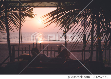 Silhouette of a person relaxing in a cafe and sunset on the main beach of Gokarna, Karnataka, India Silhouette of a person relaxing in a cafe and sunset on the main beach of Gokarna, Karnataka, India 84252340