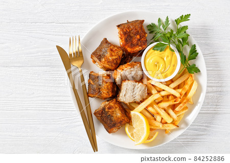 fried pieces of hake on a plate with french fries 84252886