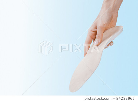 Orthopedic insole isolated on a blue background. Medical insoles. Treatment and prevention of flat feet and foot diseases. Foot care, feet comfort. Wear comfortable shoes. Flat Feet Correction. Orthopedic insole isolated on a blue background. Medical insoles. Treatment and prevention of flat feet and foot diseases. Foot care, feet comfort. Wear comfortable shoes. Flat Feet Correction. 84252965