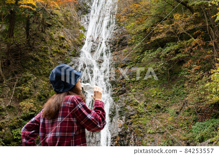 休息在秋葉瀑布的中間婦女 休息在秋葉瀑布的中間婦女 84253557