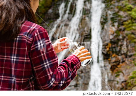休息在秋葉瀑布的中間婦女 84253577