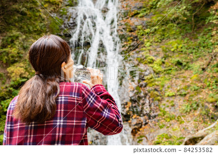 休息在秋葉瀑布的中間婦女 休息在秋葉瀑布的中間婦女 84253582