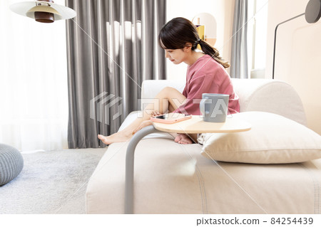 Woman relaxing in the living room 84254439