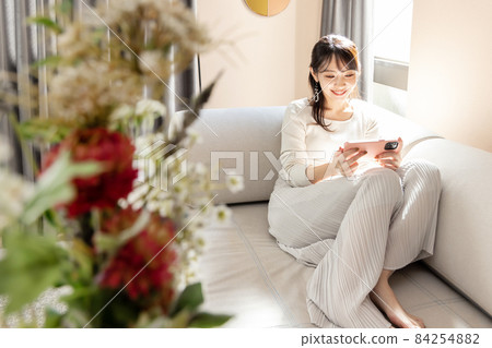Woman relaxing in the living room Woman relaxing in the living room 84254882