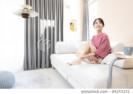 Woman relaxing in the living room 84255231