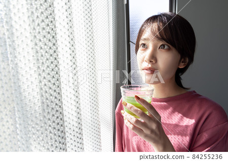 A woman drinking a green smoothie 84255236