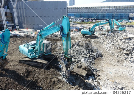 Building demolition work site with large heavy machinery demolished 84256217