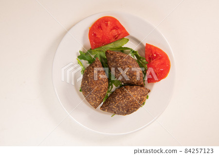 Traditional kebbe and pita bread on big round plate in lebanese restaurant Traditional kebbe and pita bread on big round plate in lebanese restaurant 84257123
